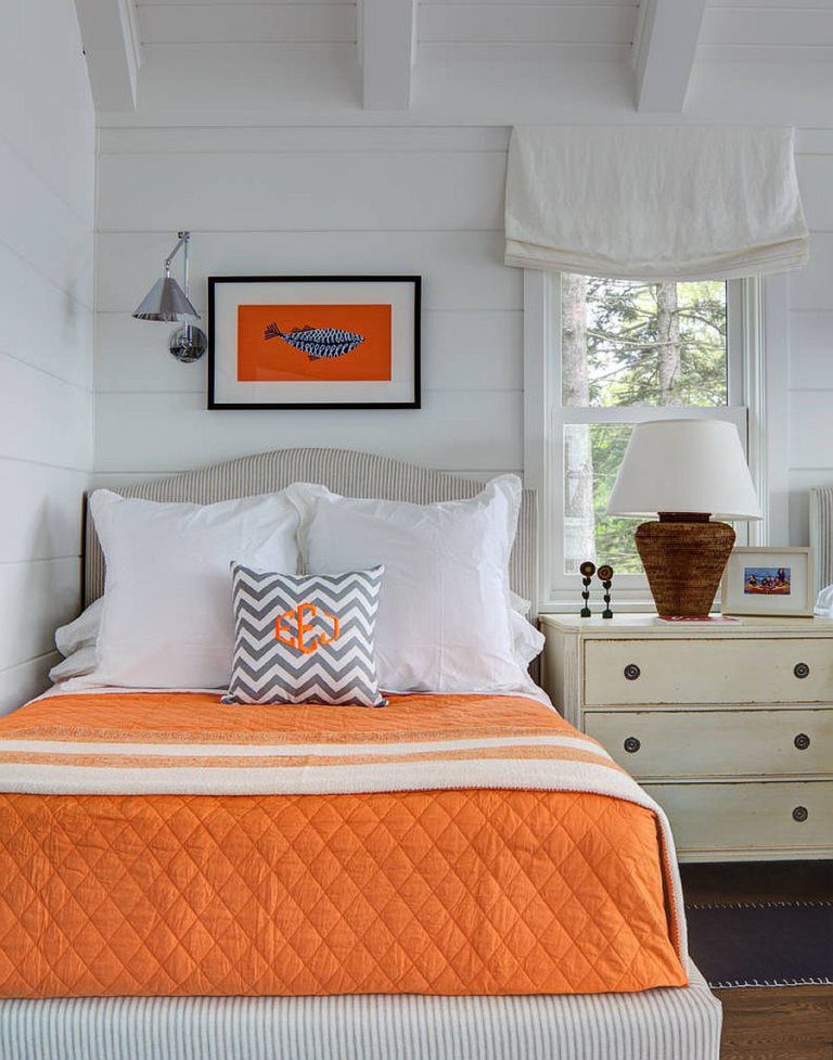 hình ảnh phòng ngủ phong cách ven biển với điểm nhấn màu cam từ ga gối và tranh treo đầu giường